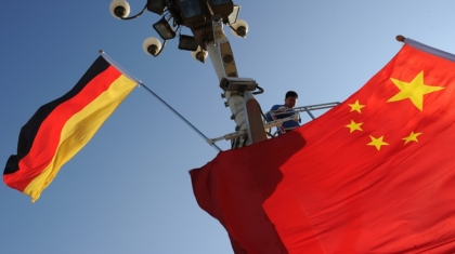 Workers install German and Chinese flags