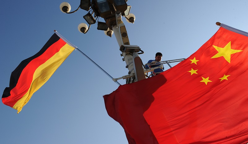 Workers install German and Chinese flags