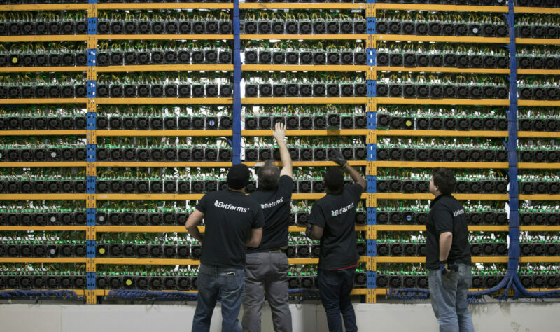 Workers check the fans on miners, the computing power to the cryptocurrency farming operation seen at Bitfarms in Farnham, Quebec, Canada, on Wednesday, January 24, 2018.  Photographer: Christinne Muschi/Bloomberg
