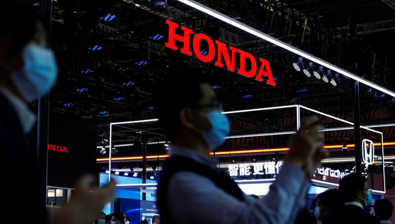 FILE PHOTO: Visitors stand near the Honda booth during a media day for the Auto Shanghai show in Shanghai, China April 19, 2021. REUTERS/Aly Song/File Photo