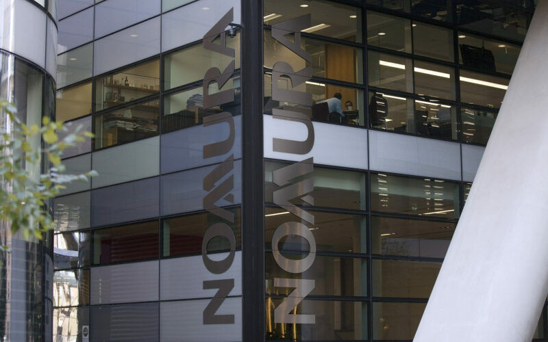 The Nomura company logo is seen on display at the U.K. headquarters of Nomura Asset Management Ltd, part of the Nomura Holdings Inc group in London, U.K., on Thursday, Sept.6, 2012. Nomura Holdings Inc. aims to derive almost half of its $1 billion in planned savings from Europe, where it will cut jobs for managing directors and back-office staff, two people with direct knowledge of the matter said. Photographer: Simon Dawson/Bloomberg